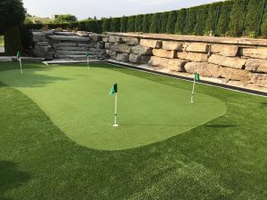 Stunning golf green and fringe turf with large Armour stone wall 